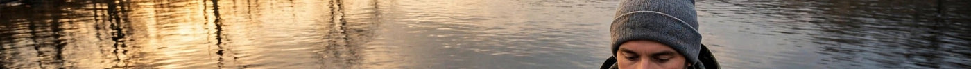 Angler holding a smallmouth bass on a late-fall Ontario lake at golden hour